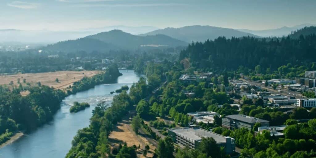 Aerial view of a river winding through Oregon's landscape, highlighting potential locations where solar panels would be worth installing to maximize renewable energy production