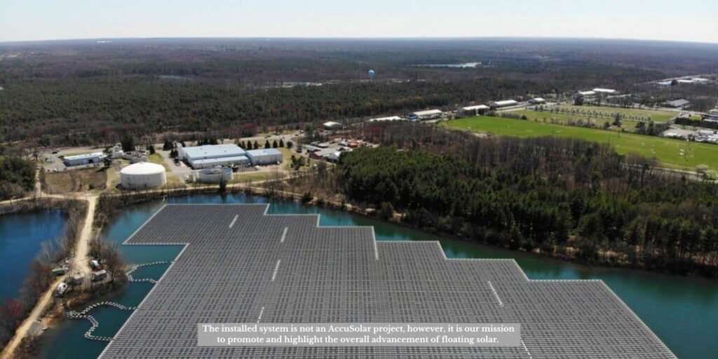 A large floating solar farm on a reservoir near an industrial area, highlighting the importance of a bathymetric survey for proper site selection and anchoring.