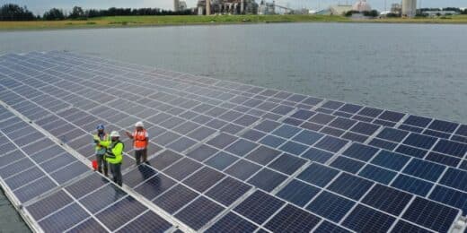 Technicians inspecting a floating solar panel array on water