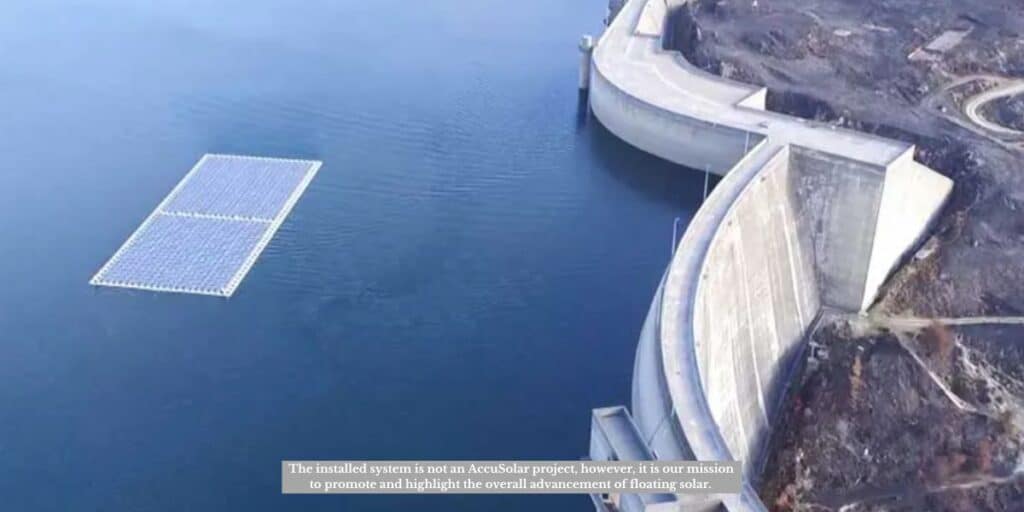An aerial view of a floating solar panel array on the surface of a reservoir near a large concrete dam. This setup demonstrates how floating solar panels work by converting sunlight into electricity while utilizing unused water surfaces.