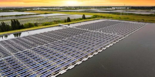Aerial view of the world’s largest floating solar power plant showing rows of solar panels on water generating renewable energy at sunset.