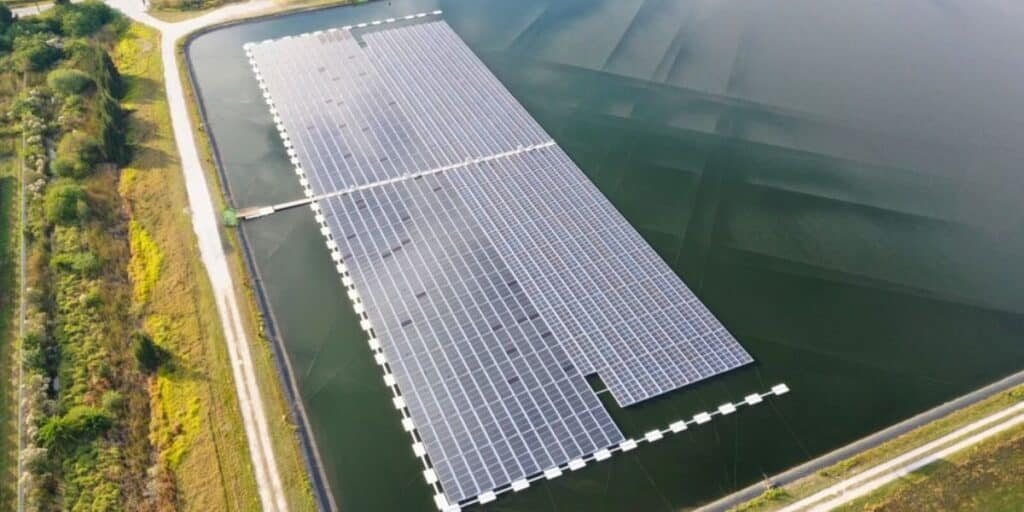 An illustration of land preservation by having floating solar panels on a body of water.